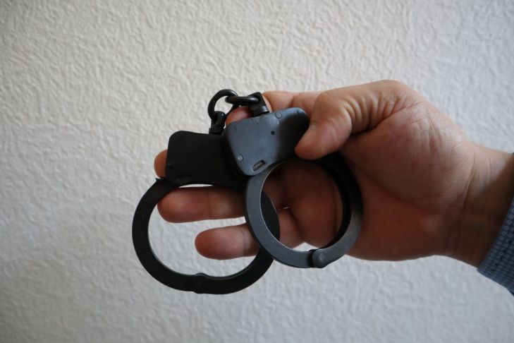 Man Who Threatened to Kill Singer Taylor Swift Arrested in Germany handcuffs